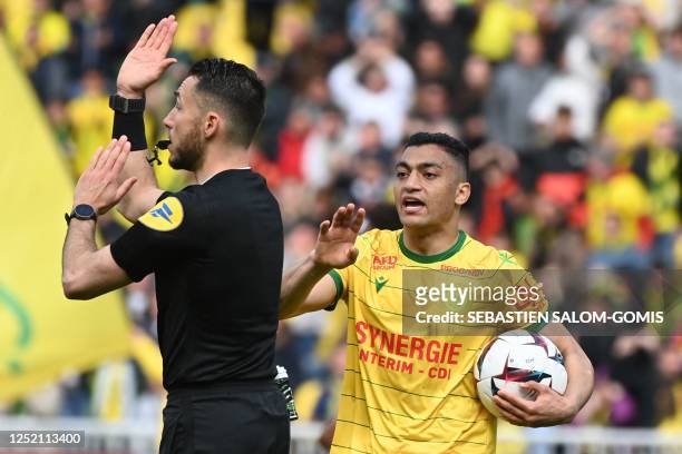 Nantes' Egyptian forward Mostafa Mohamed talks to the French referee Jeremie Pignard as the goal is checked by the VAR during the French L1 football...
