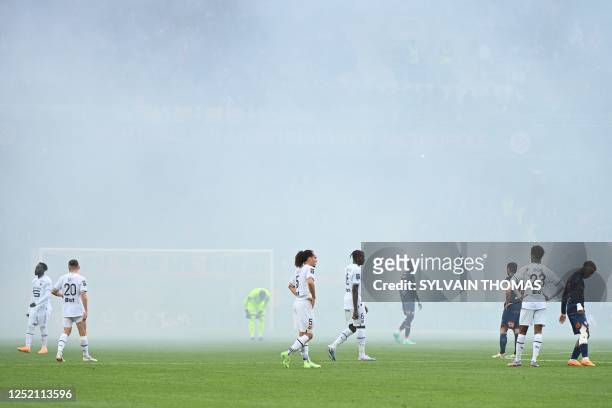 Players look on as the smoke from flares lit by supporters cover the pitch during the French L1 football match between Montpellier Herault SC and...