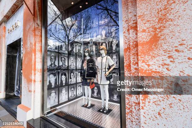 Orange paint sprayed by activists from the "Last Generation" climate action movement on a GUCCI shop on the famous shopping avenue of Kurfürstendamm...