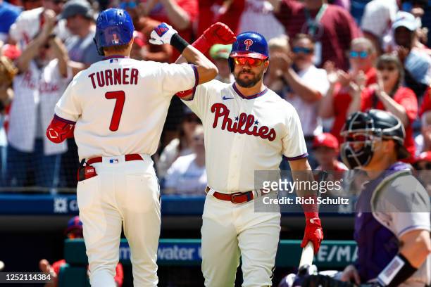 Trea Turner of the Philadelphia Phillies is congratulated by Kyle Schwarber after hitting a home run against the Colorado Rockies during the first...