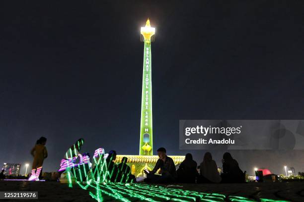 Visitors watch a video mapping show at the Monas area in Jakarta Indonesia on April 23, 2023. In conjunction Eid-al Fitr holidays, the Jakarta...