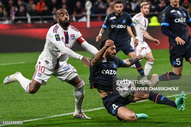 Marseille's French defender Samuel Gigot fights for the ball with Lyon's French forward Alexandre Lacazette during the French L1 football match...