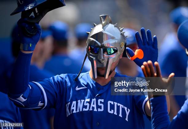 Vinnie Pasquantino of the Kansas City Royals is greeted in the dugout wearing a gladiator mask after hitting a solo home run in the sixth inning...
