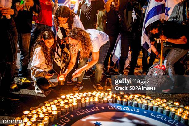 Israelis light candles at a memorial during an anti reform demonstration in Tel Aviv. Hundreds of people rallied for the 16th straight week Saturday...