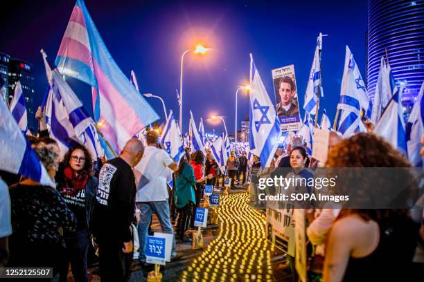 Bereaved family members hold a photo of their loved one next to a candle memorial during an anti reform demonstration in Tel Aviv. Hundreds of people...