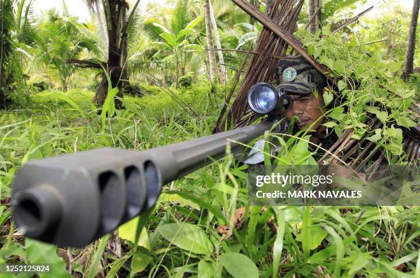 Moro Islamic Liberation Front rebel aims his .50 calibre Barret sniper rifle during a drill at camp Rajamuda in north Cotabato in Mindanao island...