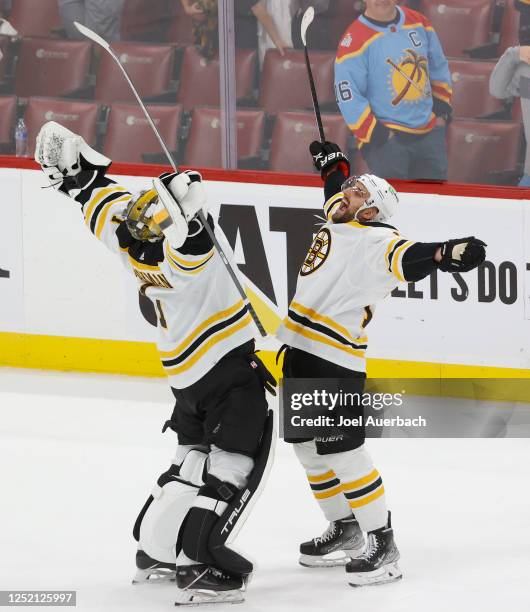 Goaltender Jeremy Swayman and Nick Foligno of the Boston Bruins celebrate the 6-2 win against the Florida Panthers in Game Four of the First Round of...