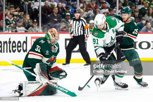 Filip Gustavsson of the Minnesota Wild makes a save against Tyler Seguin of the Dallas Stars while Jonas Brodin of the Minnesota Wild defends in the...