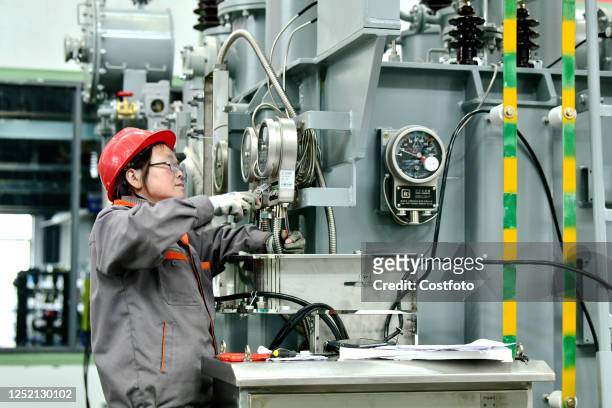 Employees rush to make an order for energy-saving transformers at a workshop in Nantong, Jiangsu Province, China, April 24, 2023.
