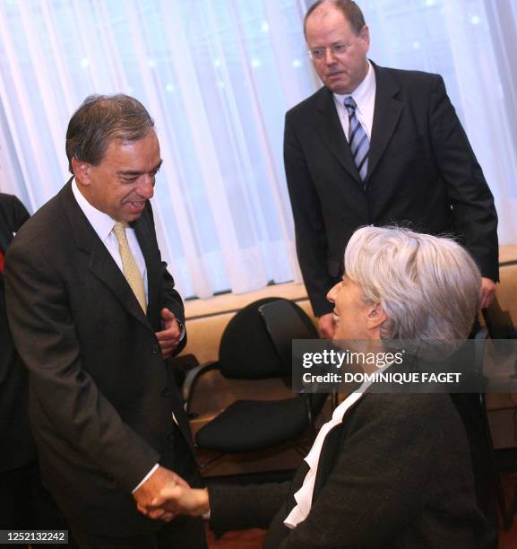 New Finance Minister of Cyprus Charilaos Stavrakis greets his French couterpart Christine Lagarde as German Finance Minister Peer Steinbruck looks on...