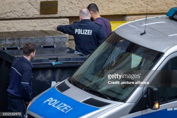 April 2023, North Rhine-Westphalia, Duisburg: A suspect is led into the courthouse by a police officer. Six days after the attack in a Duisburg gym,...