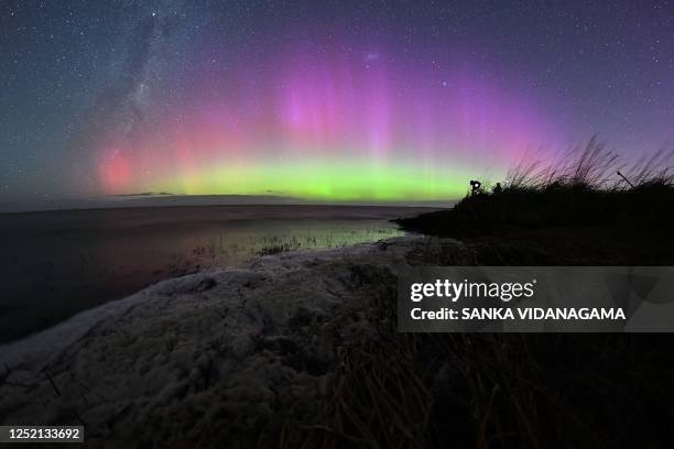 The Aurora Australis, also known as the Southern Lights, glow on the horizon over waters of Lake Ellesmere on the outskirts of Christchurch on April...