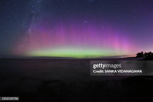 The Aurora Australis, also known as the Southern Lights, glow on the horizon over waters of Lake Ellesmere on the outskirts of Christchurch on April...