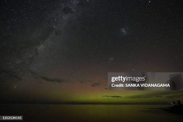 The Aurora Australis, also known as the Southern Lights, glow on the horizon over waters of Lake Ellesmere on the outskirts of Christchurch on April...