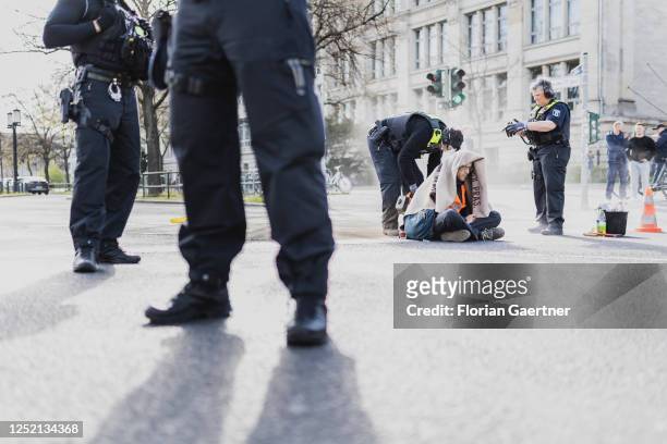Climate activist of the protest movement 'Letzte Generation' is cut out of the street on Ernst-Reuter-Platz on April 24, 2023 in Berlin, Germany. The...