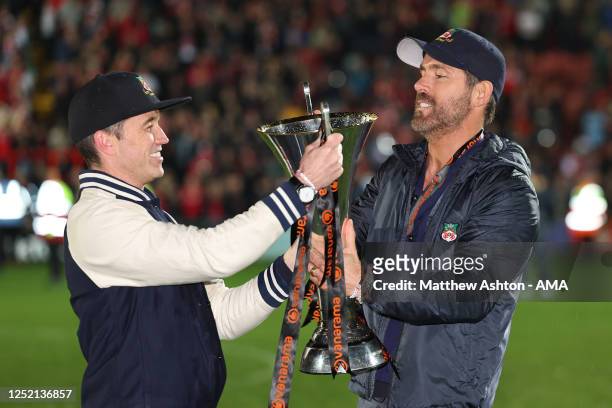 Wrexham owners Rob McElhenney and Ryan Reynolds hold the Vanarama National League Trophy as Wrexham celebrate promotion back to the English Football...