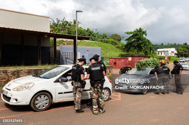 French gendarmes control cars in Koungou city, on April 24, 2023. - Preparations were carried out on April 24, 2023 in a shanty town in the commune...