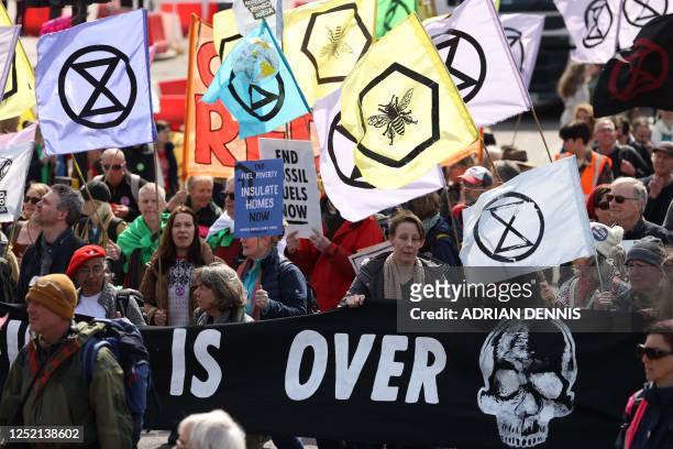 Protesters holding placards and flags march through central London on April 24, 2023 as they take part in a demonstration march to end fossil fuels...