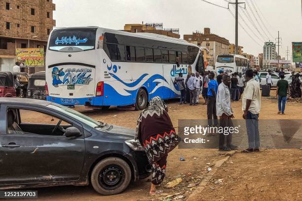 People prepare to board a bus departing from Khartoum in the Sudanese capital's south on April 24 as battles rage in the city between the army and...