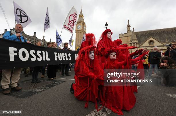 Members of performance troupe Red Rebel Brigade pose with activists, as a march by the climate change protest group Extinction Rebellion arrives...