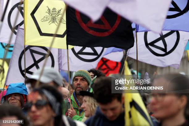 Activists wave flag as the march by the climate change protest group Extinction Rebellion arrives outside the Houses of Parliament in central London...