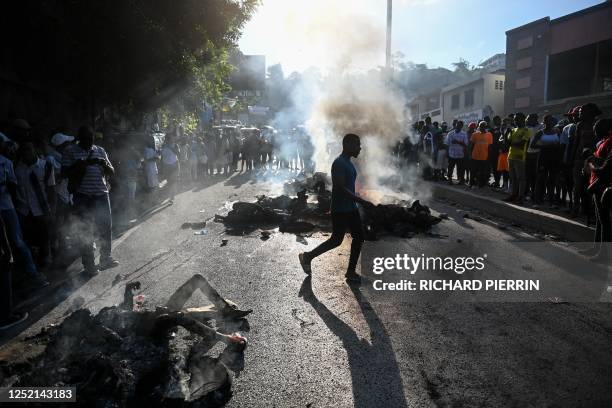 Graphic content / TOPSHOT - People look at bodies in the street after gang-related violence in the capital of Port-au-Prince, Haiti on April 24,...