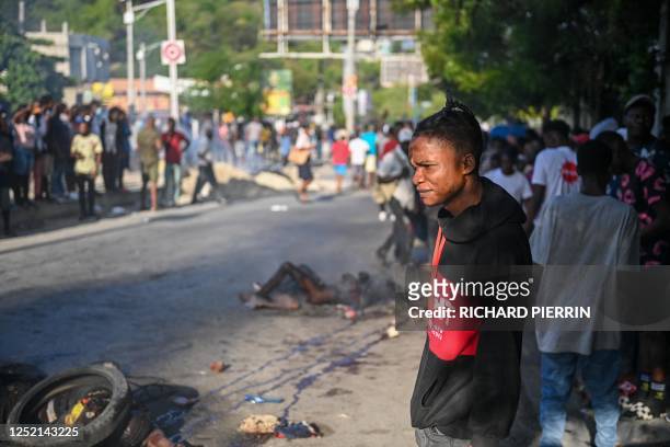 Graphic content / People look at bodies in the street after gang-related violence in the capital of Port-au-Prince, Haiti on April 24, 2023. - More...