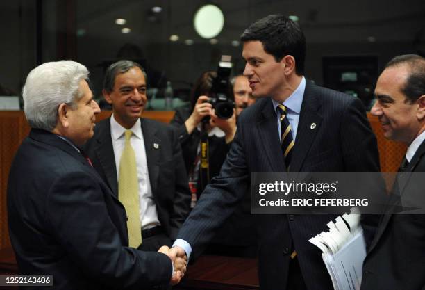 Britain's foreign secretary David Miliband shakes hands with Cyprus' President Demetris Christofias as Cyprus' Foreign Minister Markos Kyprianou and...