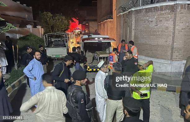 Security personnel gather at the site after multiple explosions caused by a fire in a munitions cache in a Pakistan police station in Kabal, in the...