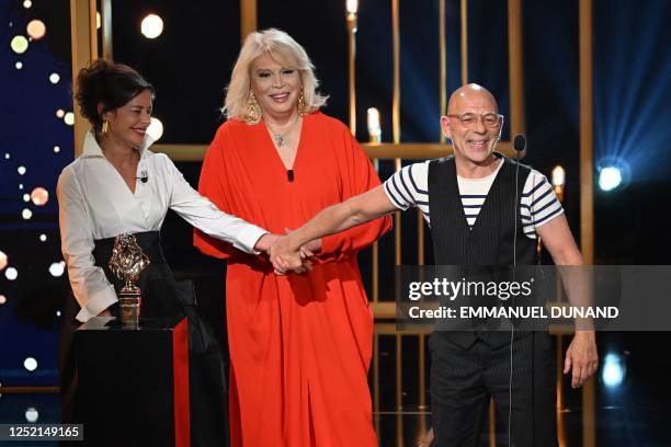 French stage director Christian Hecq , flanked by French actress, singer, TV host and painter Amanda Lear , is congratulated by his wife, French...