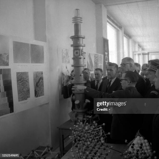 French President Charles De Gaulle and Transports minister Robert Buron look at a giant electronic microscope on February 15, 1959 during their visit...