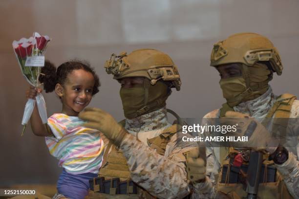 Member of the Saudi armed forces carries a girl who arrived at King Faisal navy base in Jeddah, following a rescue operation from Sudan. A ship...