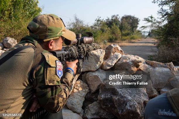 Soldier from the Karen National Liberation Army assisting the Karenni Nationalities Defence Force is aiming with his rifle towards the frontline...