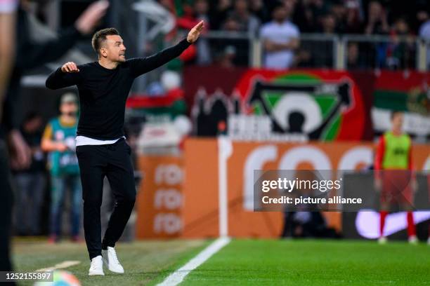 April 2023, Bavaria, Augsburg: Soccer: Bundesliga, FC Augsburg - VfB Stuttgart, Matchday 29, WWK Arena. Augsburg's coach Enrico Maaßen gestures....