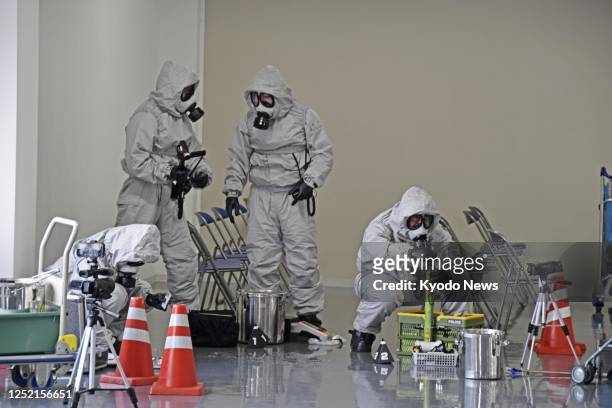 Police officers check suspicious objects at Narita airport in Chiba Prefecture, near Tokyo, on April 25 during a drill against chemical terrorism...
