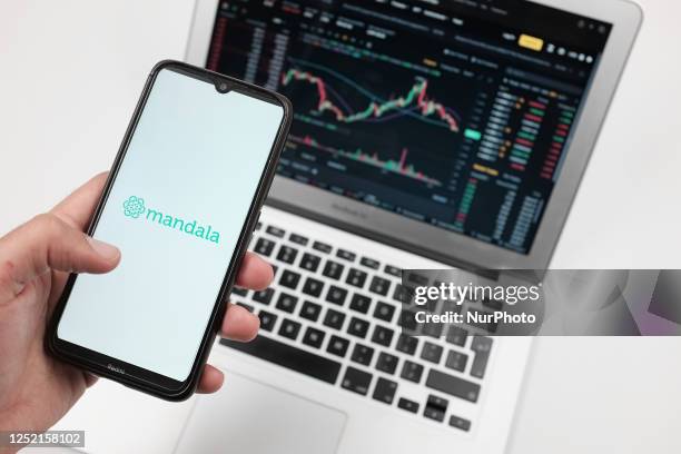 In this photo illustration a Mandala logo seen displayed on a smartphone screen and an Exchange graph on a MacBook screen in Athens, Greece on April...