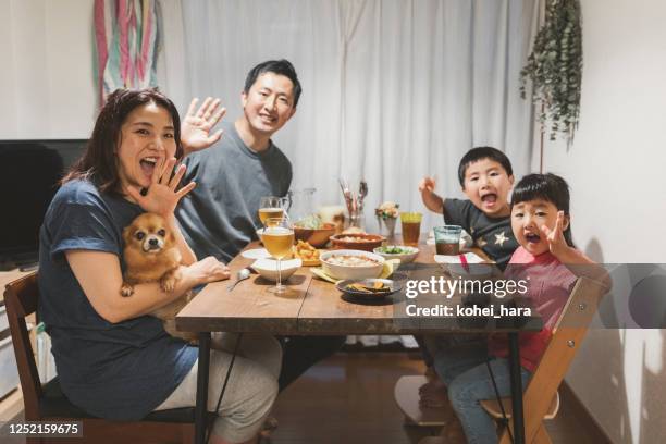 family attending online video meeting and having dinner together at home - dog waving stock pictures, royalty-free photos & images