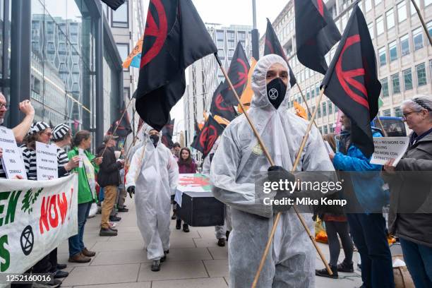 Activists from the environmental group Extinction Rebellion on a 'People's Picket' outside the Department for Energy Security and Net Zero carry a...