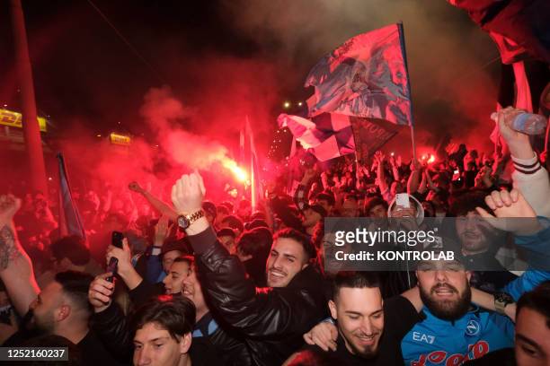 Fans celebrate in the street waving flags and burning flares after the SSC Napoli soccer team's victory against Juventus FC in Turin. With this...