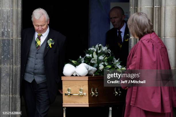 White boxing gloves lie on the coffin as it leaves the funeral ceremony of boxer Ken Buchanan at St Giles’ Cathedral on April 25, 2023 in Edinburgh,...