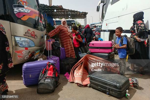 Passengers fleeing war-torn Sudan disembark at the Wadi Karkar bus station near the Egyptian city of Aswan, on April 25, 2023. - Ten days of heavy...