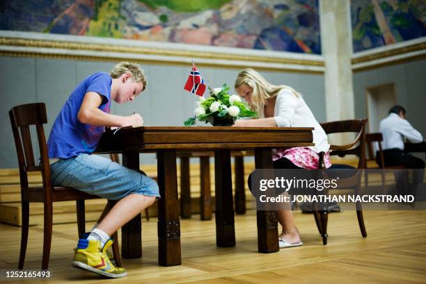 Youths write messages in honor of the victims of last Friday's twin attacks in Oslo and on the Utoeya island which left at least 76 people dead, in...