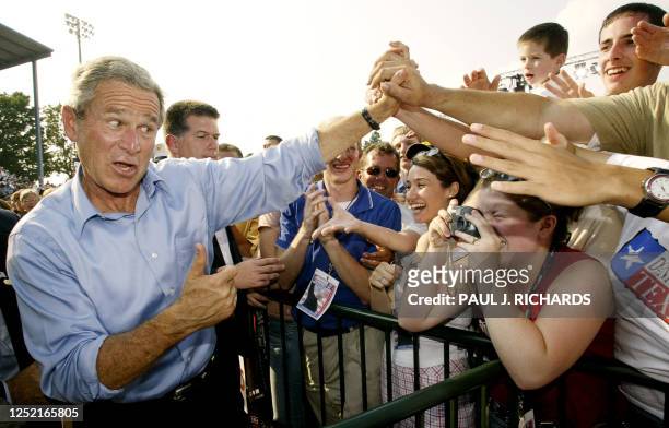 President George W. Bush jokes with a supporter wearing a "Don't Mess With Texas" t-shirt after deliverinjg remarks during a campaign rally at C.O....