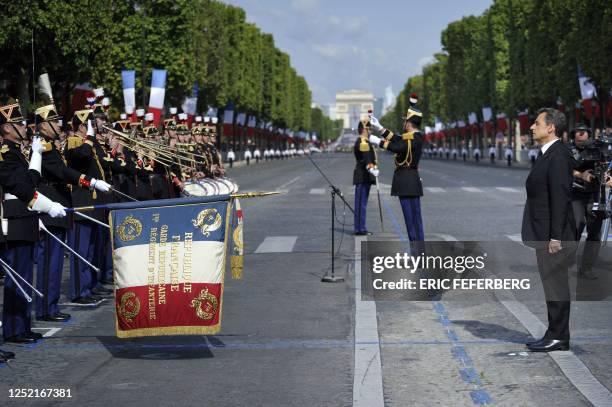 France's president Nicolas Sarkozy listens to the Republican guards 1st infantry regiment military band before the annual Bastille day parade on the...