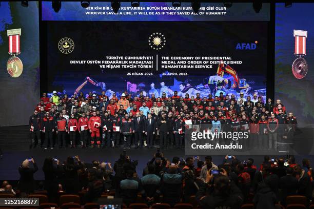 Turkish President Recep Tayyip Erdogan pose with awarded search and rescue workers who performed in the February 6 earthquake relief efforts, during...