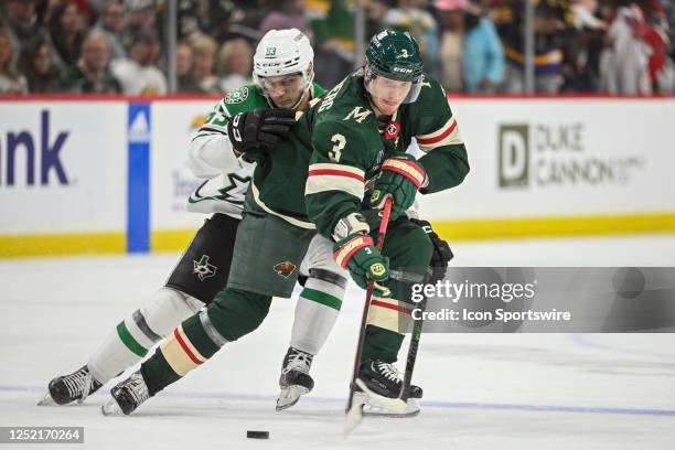 Minnesota Wild defense John Klingberg and Dallas Stars Center Wyatt Johnston battle for the puck during the third period of Game Four of the First...