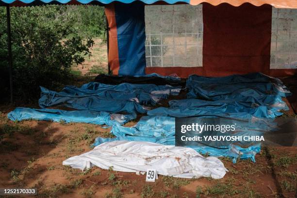 Exhumed bodies in bodybags are displayed on the ground prior to a transport to the mortuary, at the mass-grave site in Shakahola, outside the coastal...