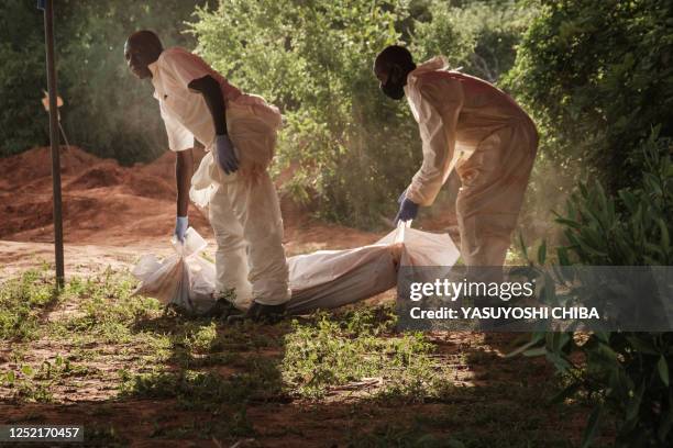 Workers carry the last bodybag to the mortuary after exhuming bodies at the mass-grave site in Shakahola, outside the coastal town of Malindi, on...