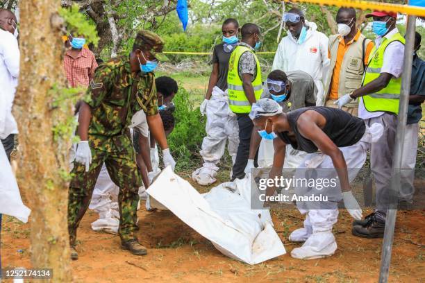 Officials carry a dead body of a person who died in Kenya's starvation cult near the Good News International Church in Malindi town of Kilifi, Kenya...