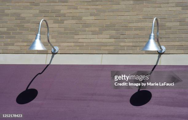 two outdoor lighting fixtures with purple awning - brick wall brass stock pictures, royalty-free photos & images
